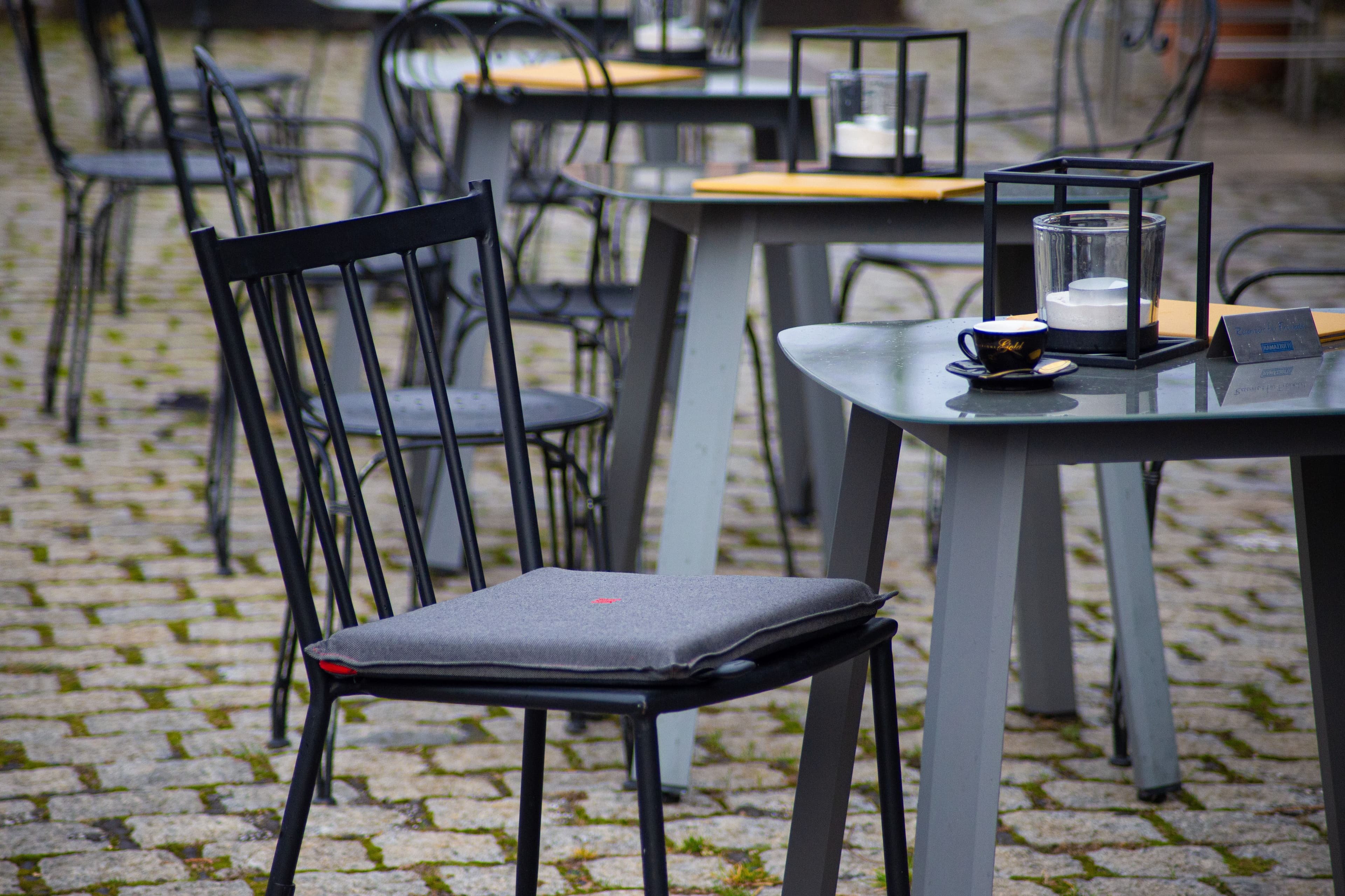 Café-Terrasse mit heatme Sitzkissen auf Kopfsteinpflaster